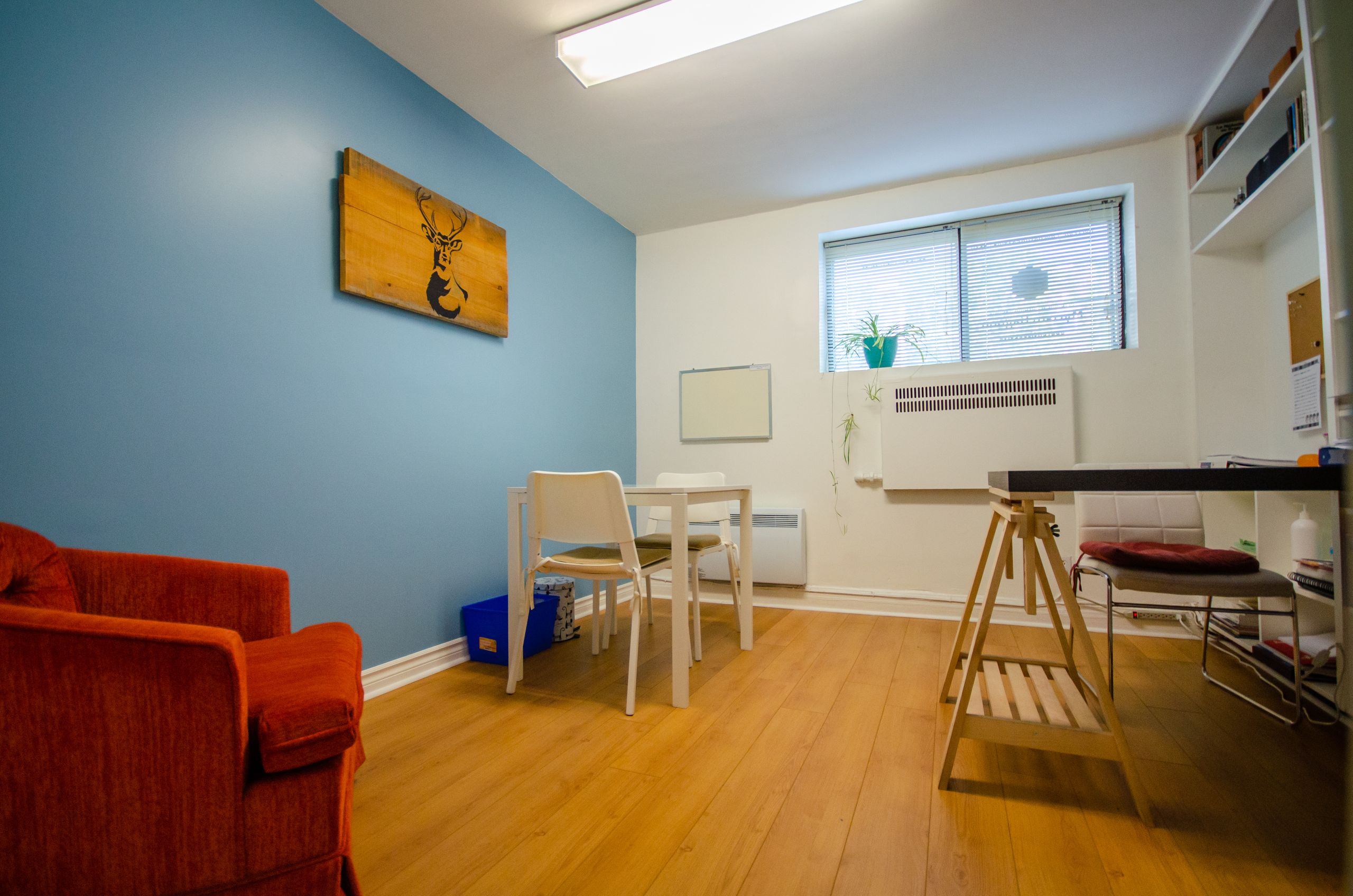 Bureau mur bleu et fauteuil orange de la clinique Myriam Gagnon